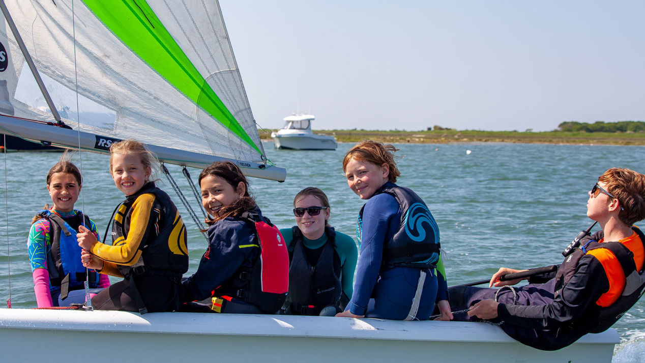 	a group of children in an RS quest sailing dinghy