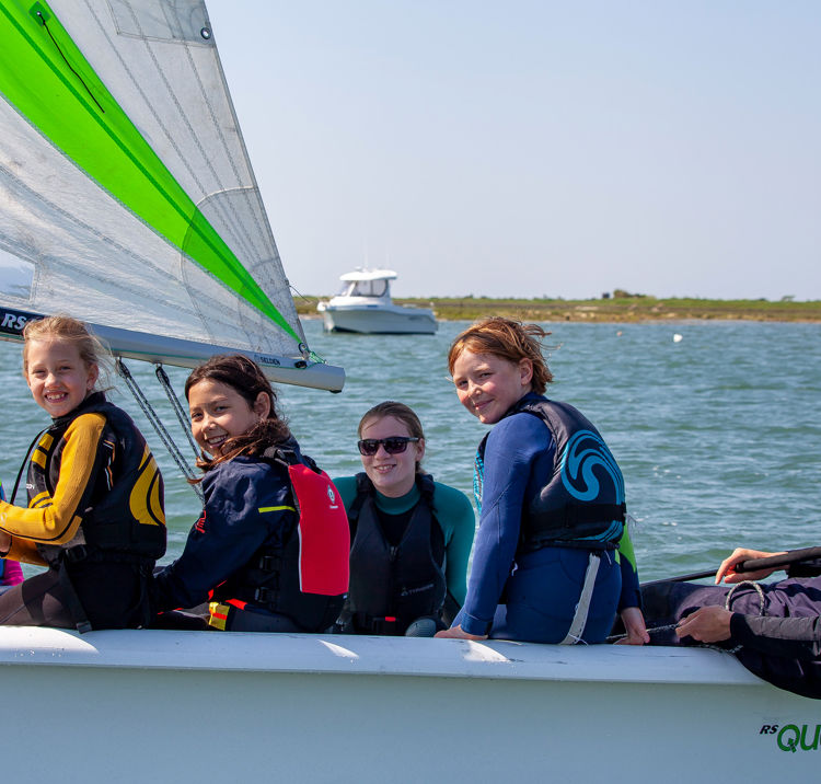 	a group of children in an RS quest sailing dinghy