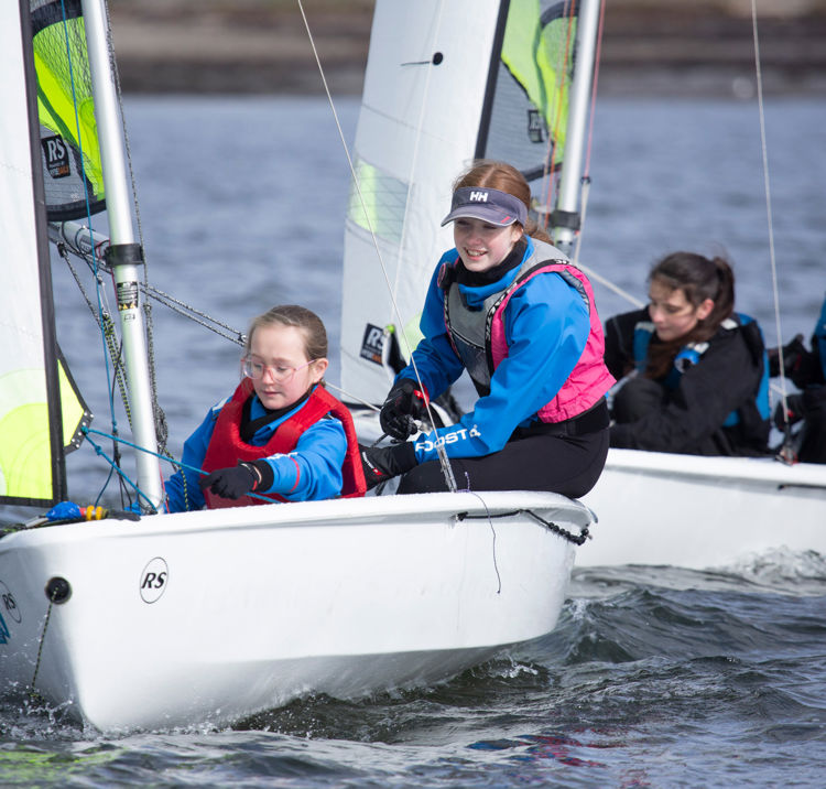 Mid shot of four sailors on two sail dinghys