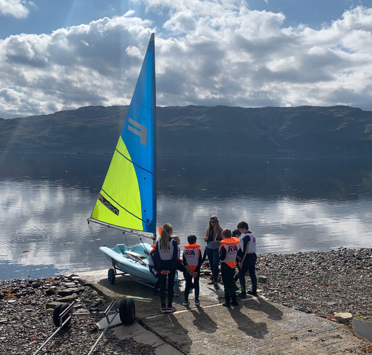 Long shot of beautiful day with sailors standing on shore being educated