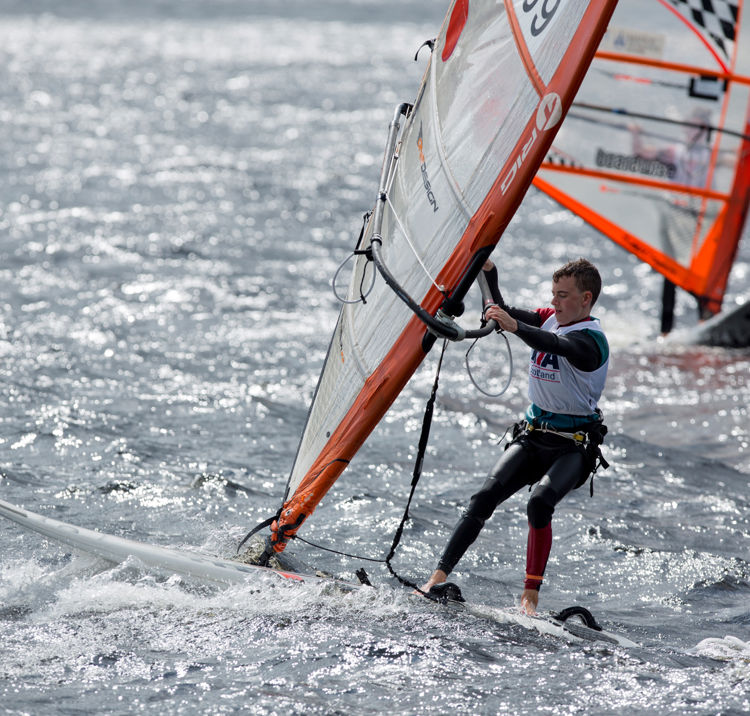 Long shot of young sailor windsurfing