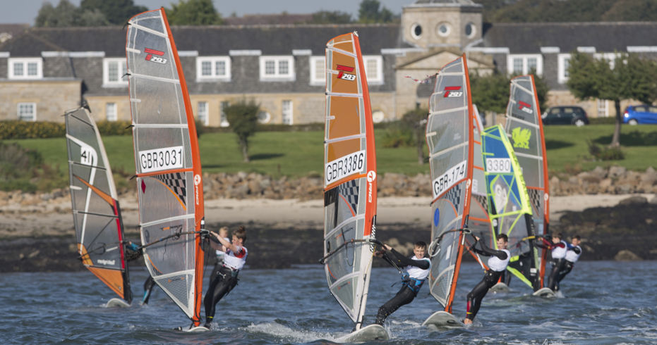 Long shot of group of sailors on windsurfs