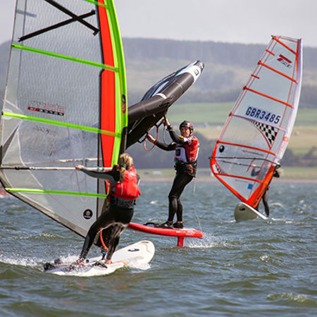 Long shot of sailors windsurfing